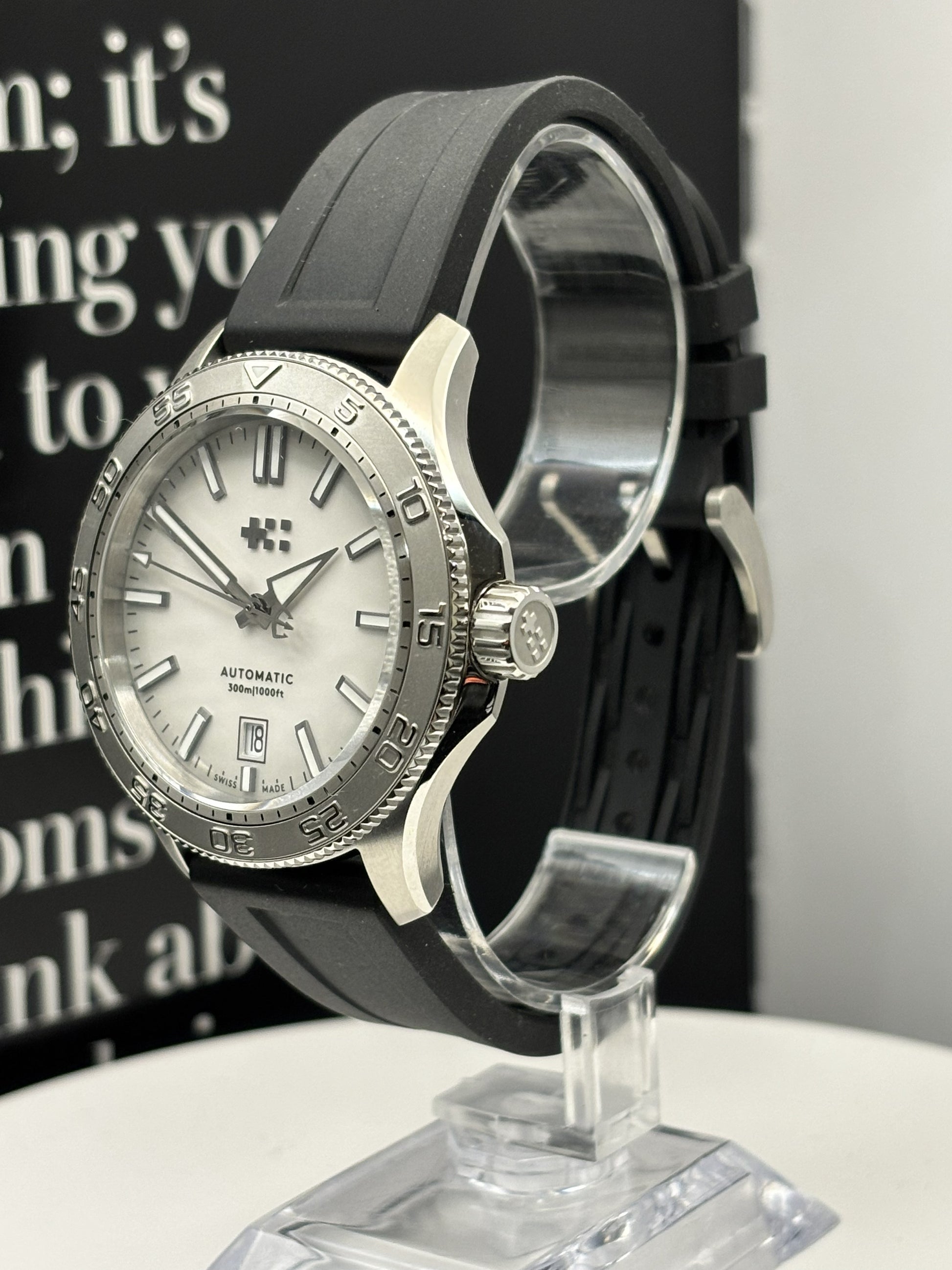 Watch with black strap on a stand against a blurred background