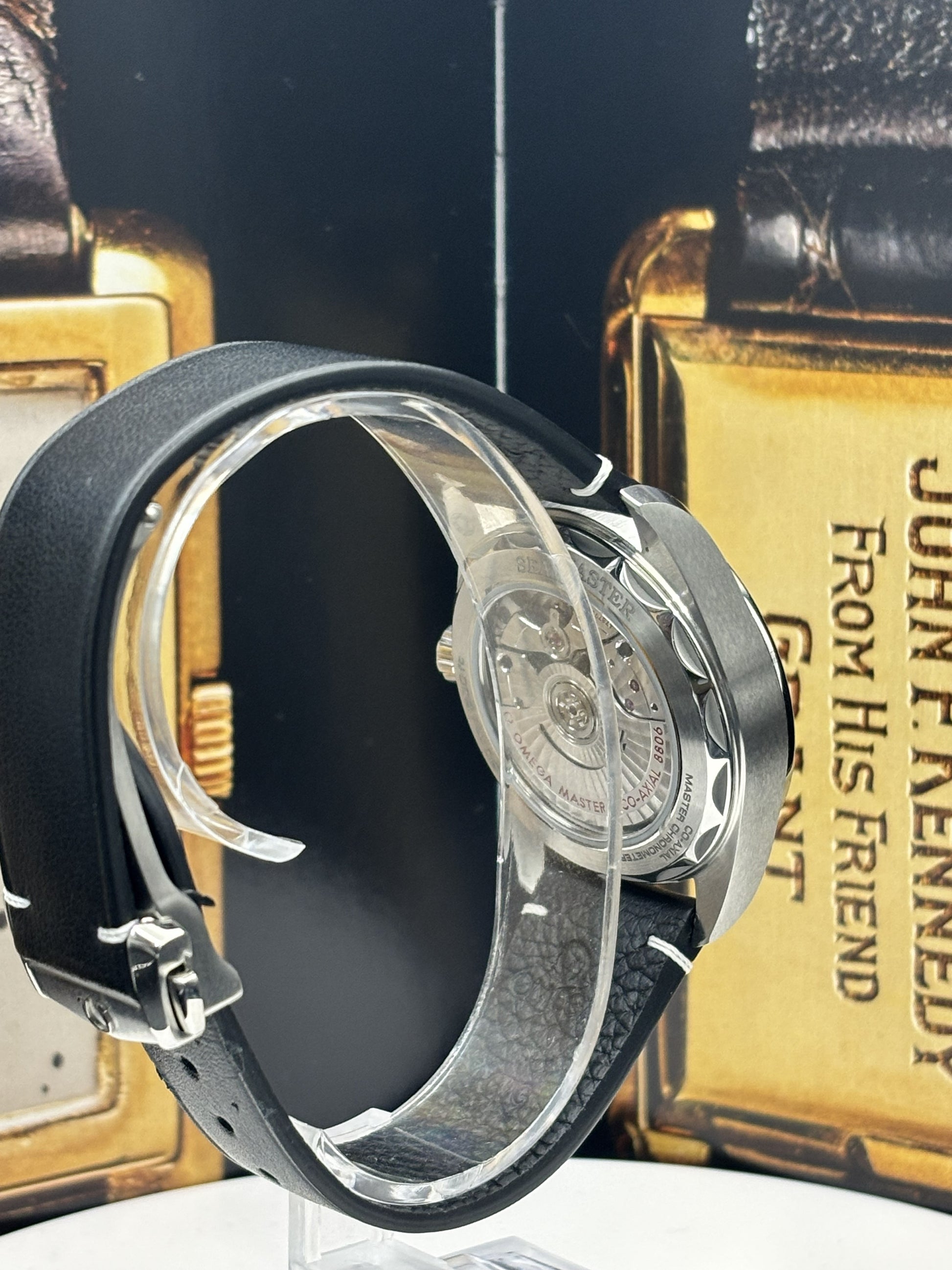 Black and silver watch with a gold box in the background