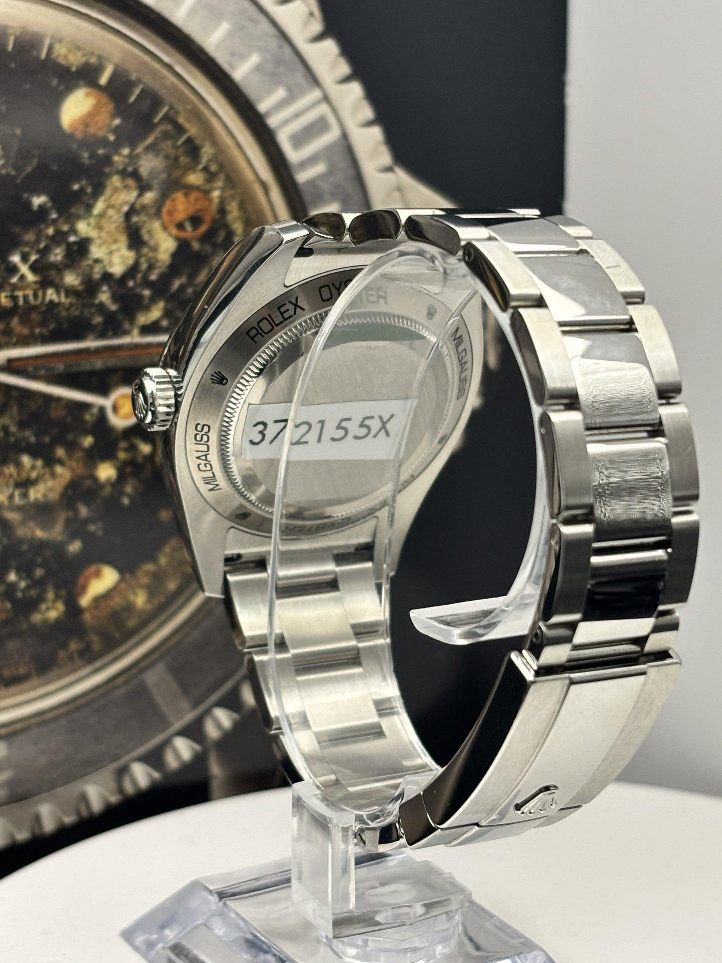 Silver watch with a clear protective cover on a stand