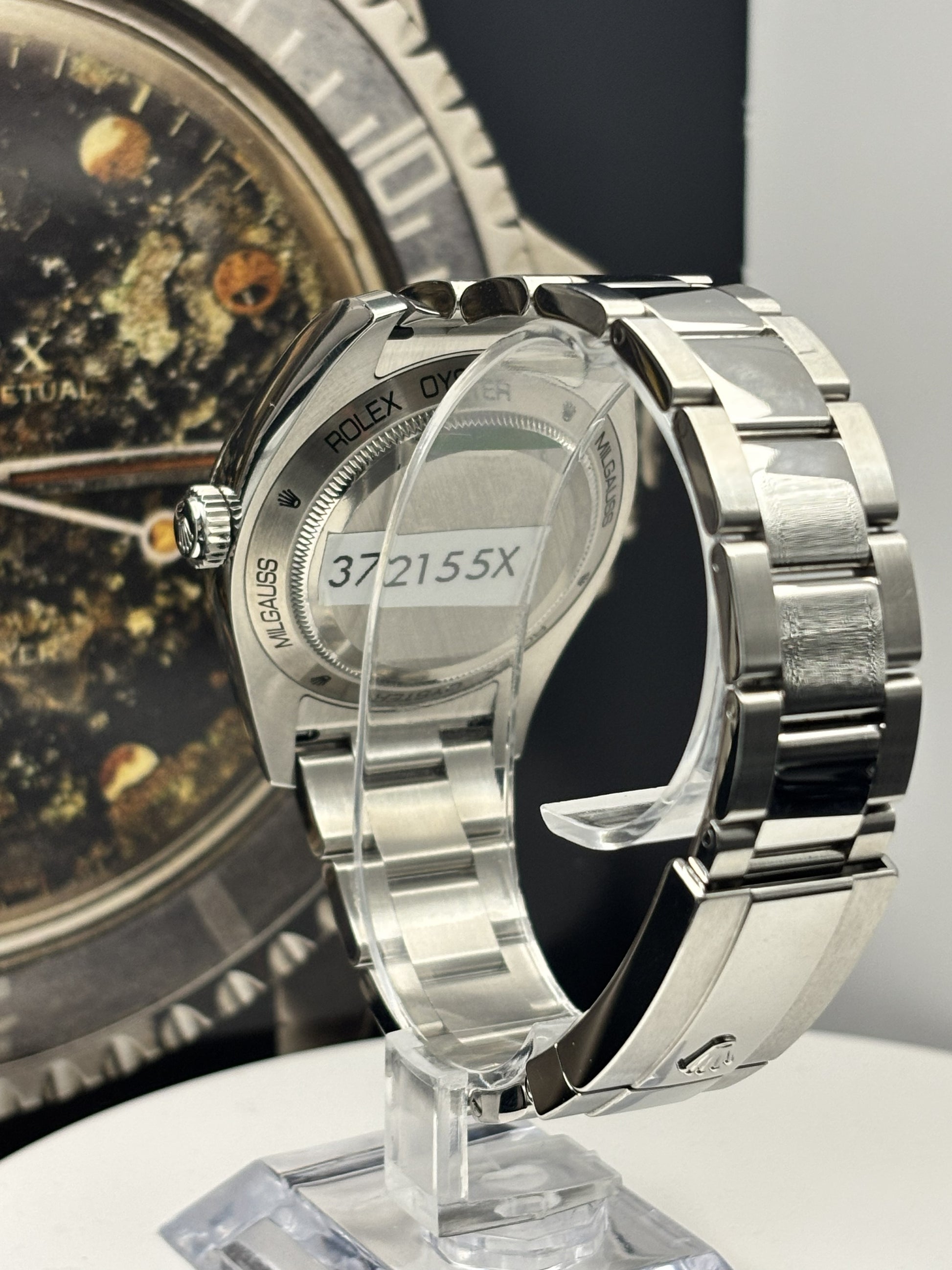 Silver watch with a clear protective cover on a stand