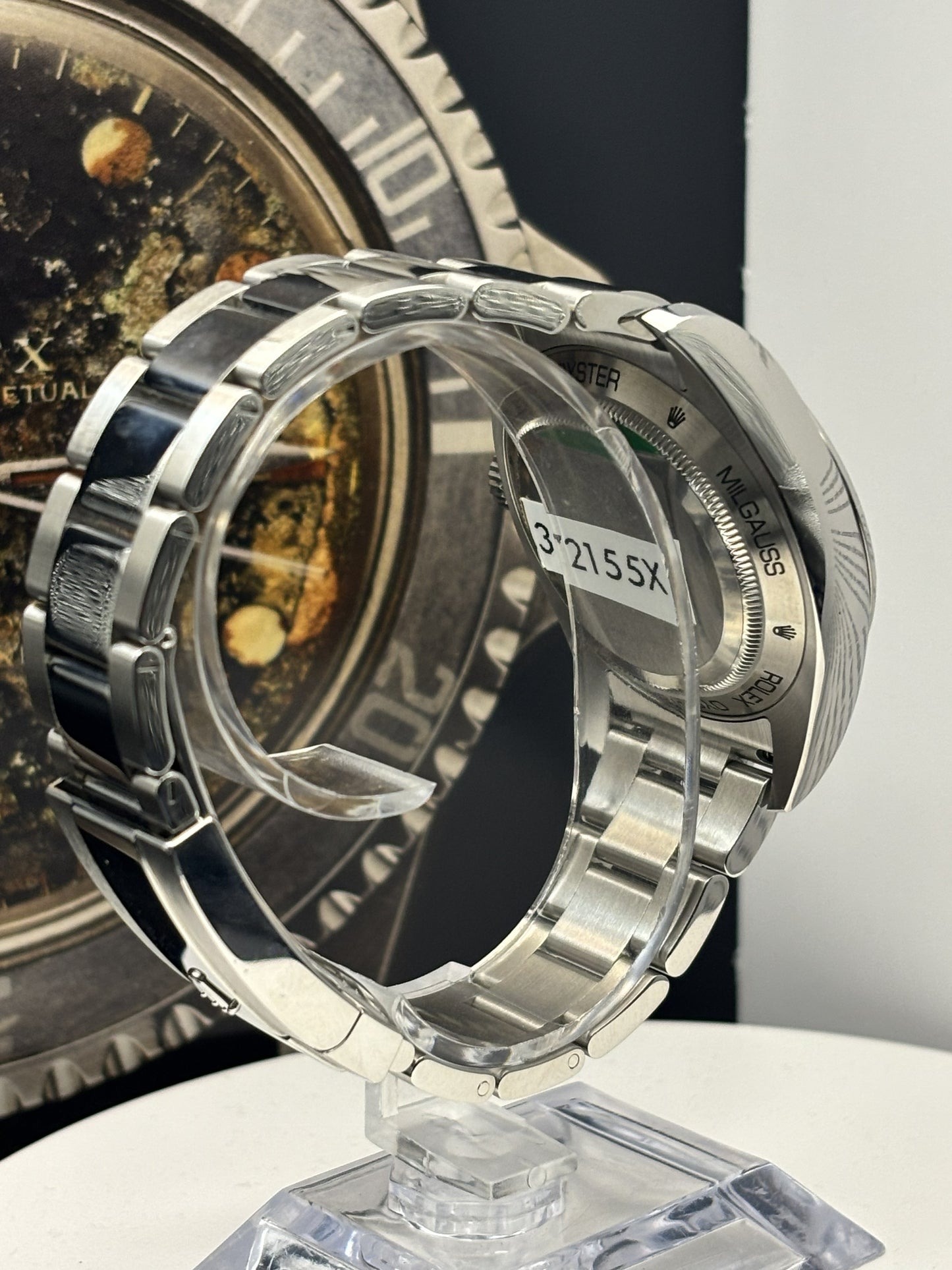 Close-up of a silver watch with a clear case back on a white surface.