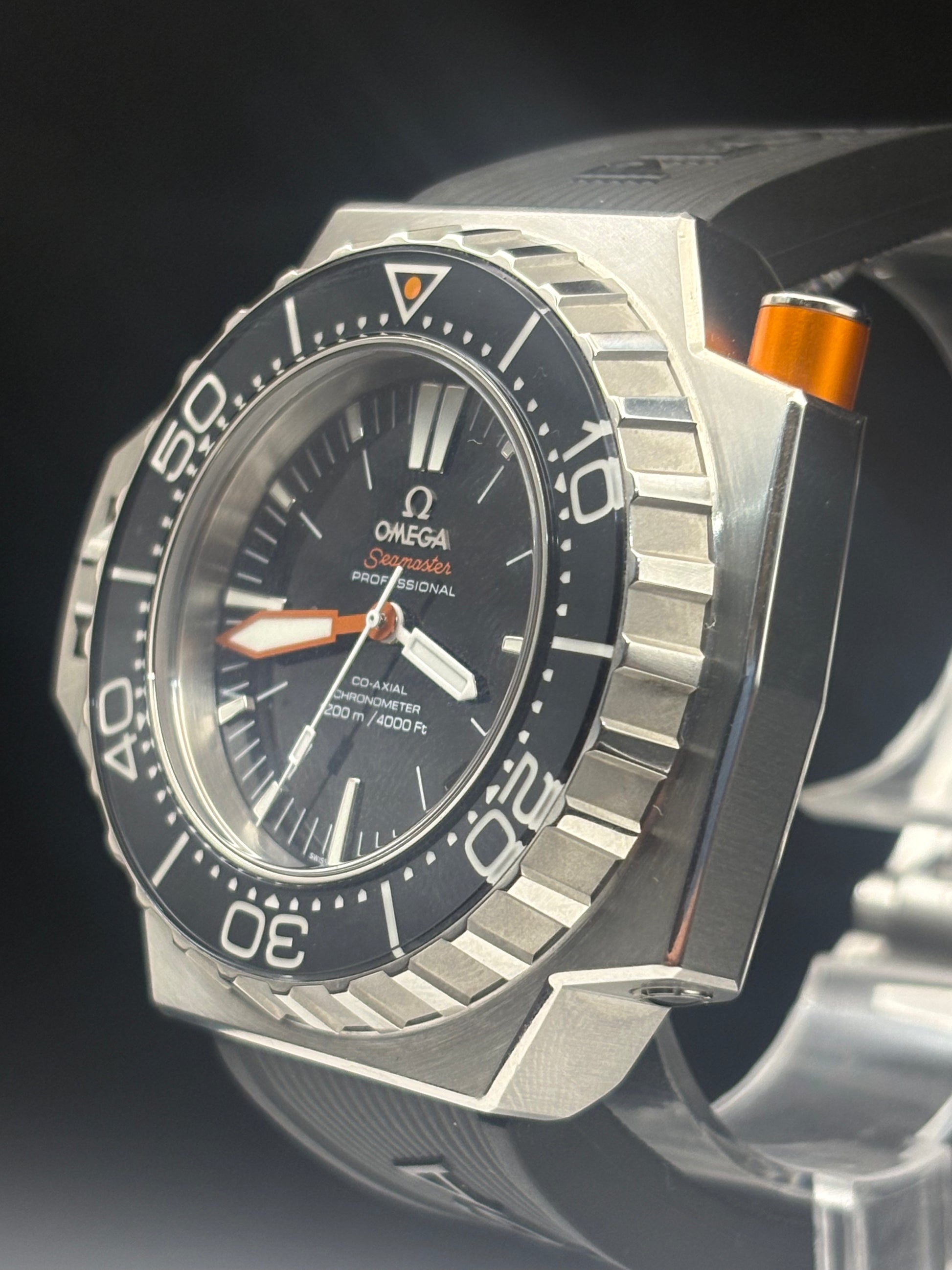 Omega Seamaster Deepsea watch with a silver stainless steel case, black dial, black rotating bezel, and orange accents, shown close-up on a dark background.