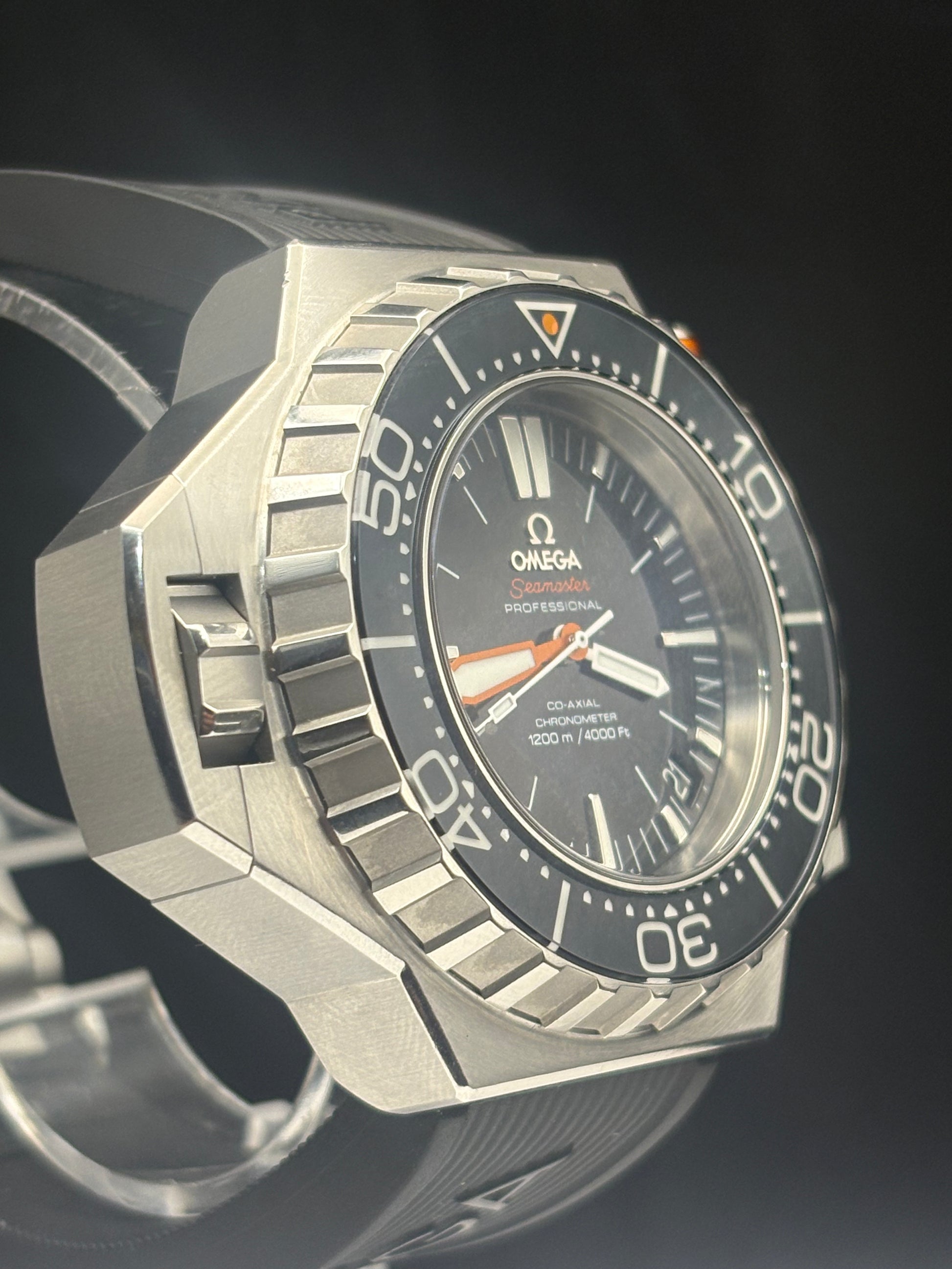Omega Professional Diver 300m watch with a silver-toned octagonal case, black dial, and black rotating bezel, shown in a close-up angled shot against a dark background.
