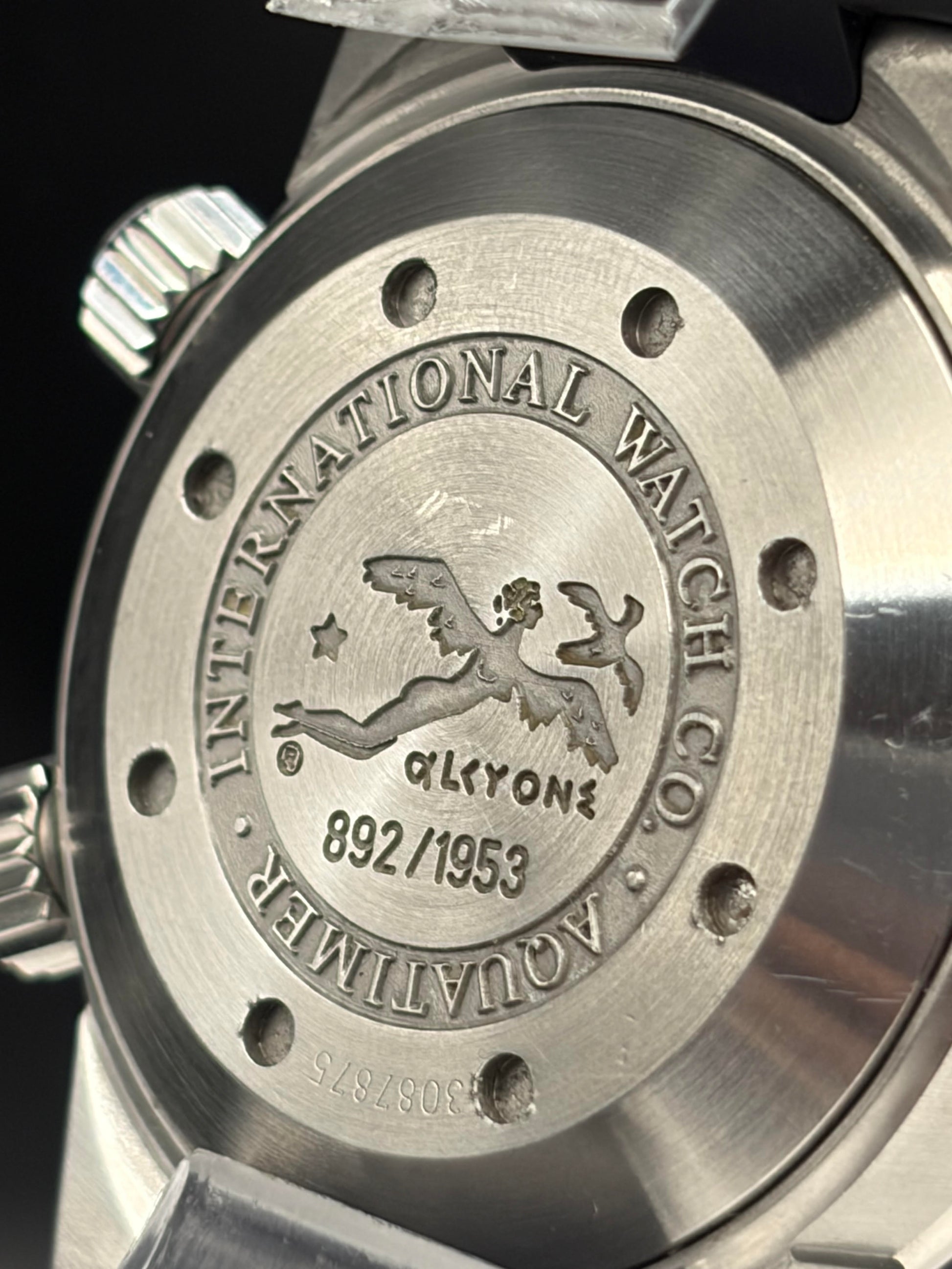 Close-up of the brushed stainless steel watch case back, featuring an engraved winged figure logo and the text 'INTERNATIONAL WATCH CO.' and 'AQUATIMER' with 'GYLYONE' in the center.