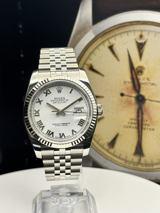 Silver watch with white face and Roman numerals on a black background
